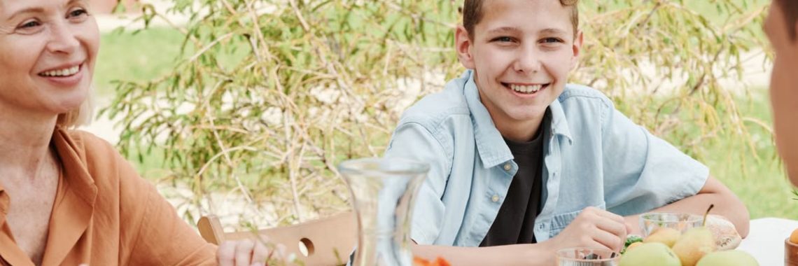 Smiling family of four dining outdoors, capturing moments of togetherness.